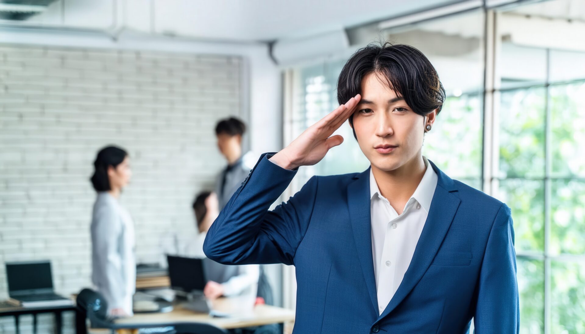 オフィスで敬礼するスーツ姿の人物