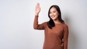 ブラウンの服で手を上げる人