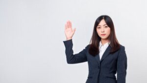 ストライプのスーツで挙手する人