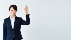 スーツ姿で手を上げる人