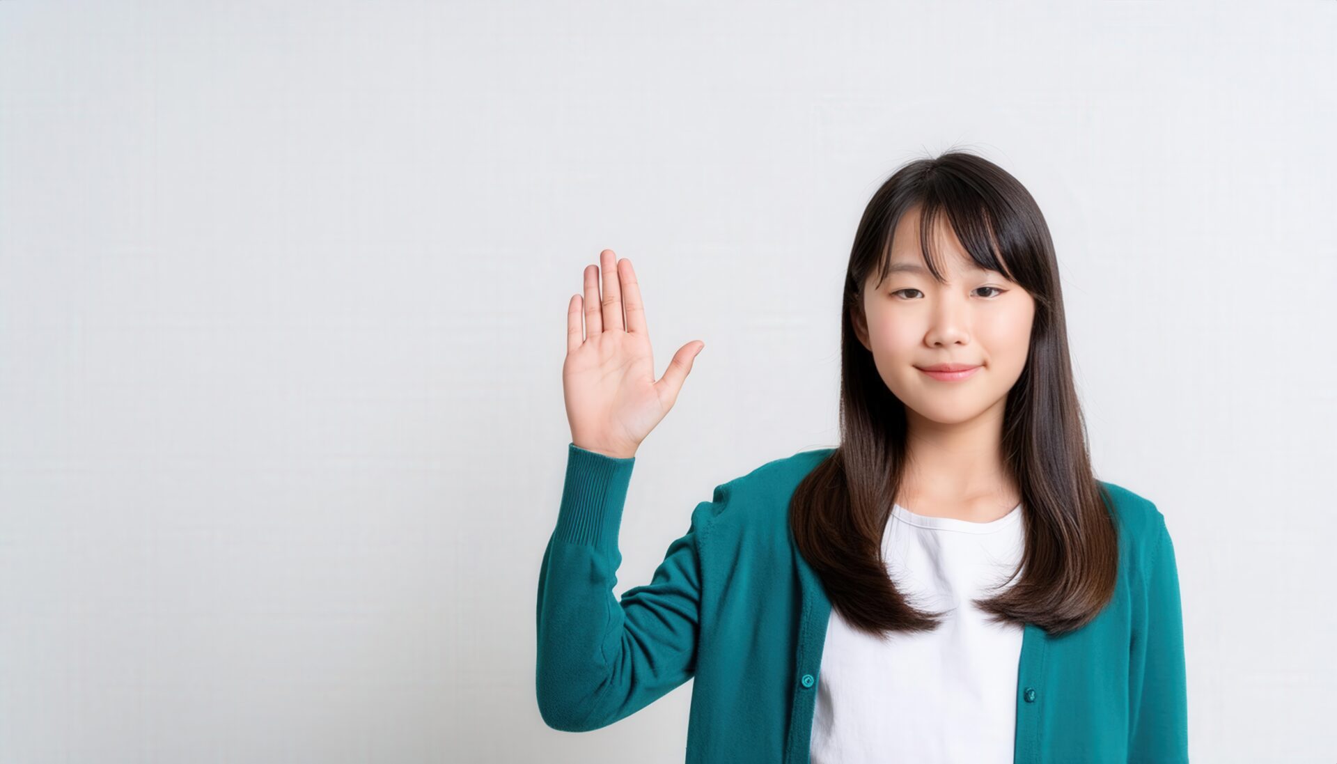 グリーンのカーディガンで手を上げる子