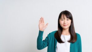 グリーンのカーディガンで手を上げる子