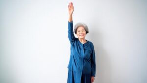 青い服を着た高齢者が腕を上げる