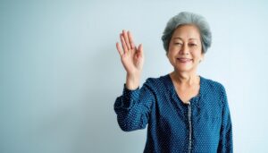 ドット柄の服で手を上げる高齢者