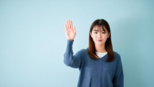 ライトブルーのセーターで手を上げる人