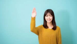 マスタード色のセーターで手を上げる人