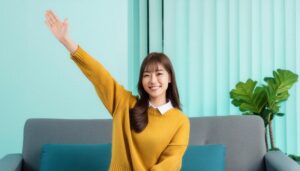 ソファに座りながら手を上げる人