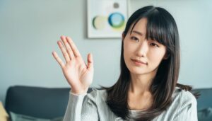 シンプルな表情で手を上げる人