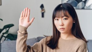 ブラウンのセーターで手を上げる人