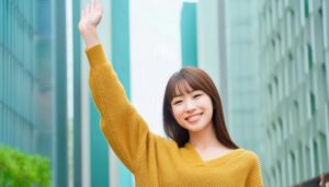 街中で大きく腕を上げる人
