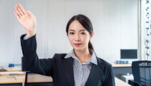 オフィス空間で腕を上げるスーツ姿の人