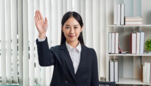 ストライプスーツで手を上げる人（オフィス）