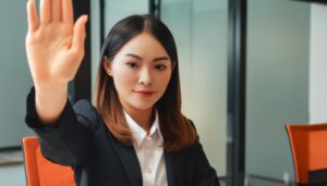 会議室で前に手を差し出すスーツ姿の人