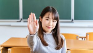 教室で挙手する笑顔の学生