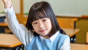 教室で挙手する笑顔の学生