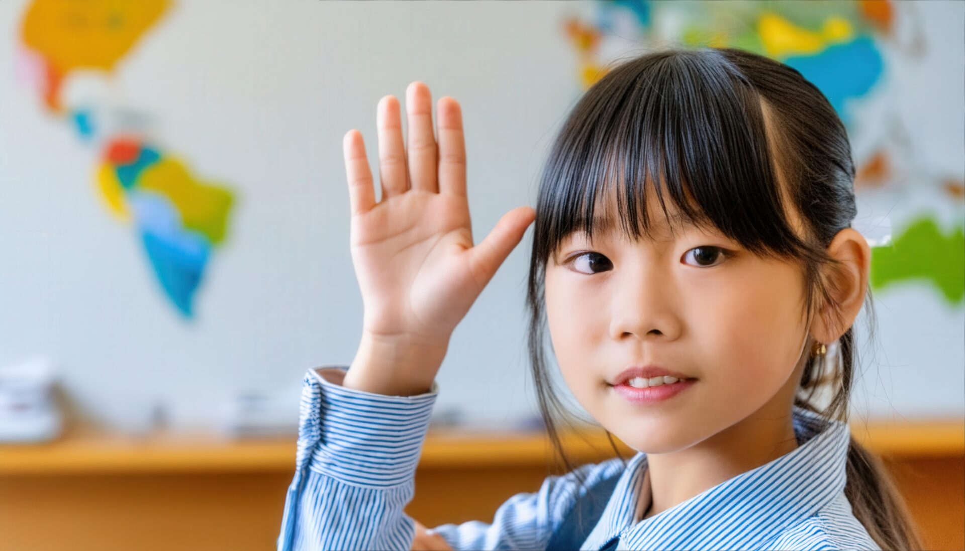 教室で挙手する笑顔の学生