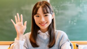 教室で挙手する笑顔の学生