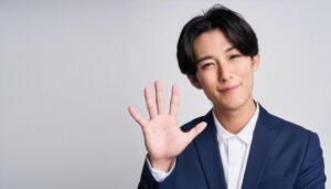 白背景で挙手するスーツ姿の男性