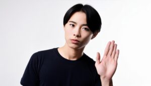 白背景で挙手する黒いTシャツの男性