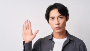 白背景で挙手するダークシャツの人物