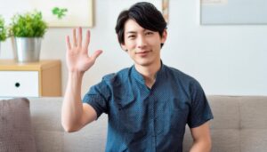 リビングで挙手する青いシャツの人物