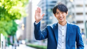 青いスーツで手を振る人