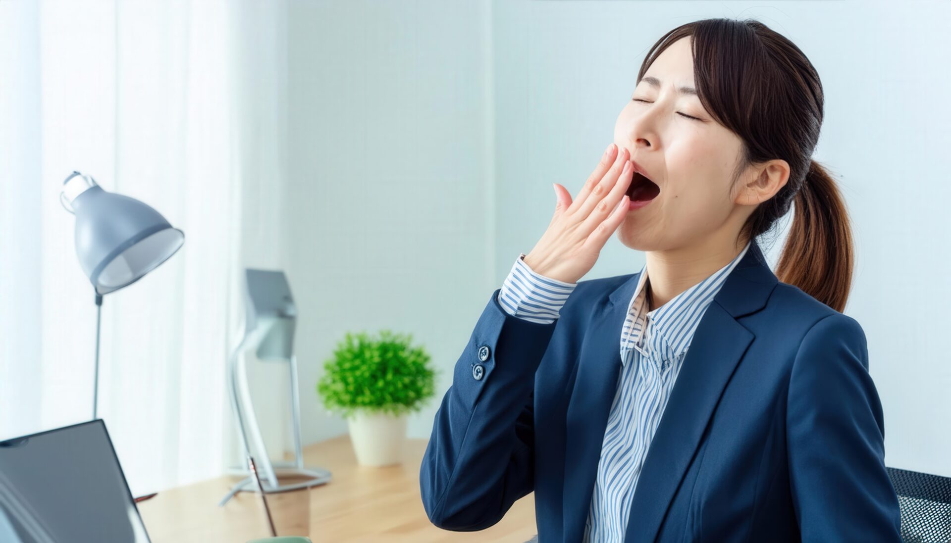 デスクであくびをする女性
