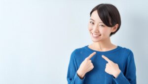 青い服で自分を指さす女性