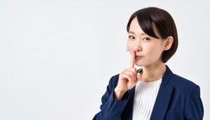 スーツ姿で内緒のジェスチャーをする人