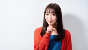 オレンジのカーディガンで黙っての合図をする人