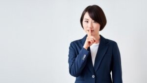 ネイビージャケットでシーと示す人