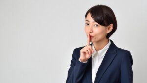 ネイビースーツで静かにのサインを示す人