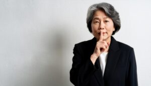 グレーヘアの人が静かにの合図をする