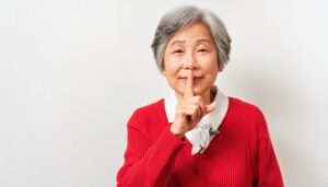 白髪の人が黙っての仕草をする