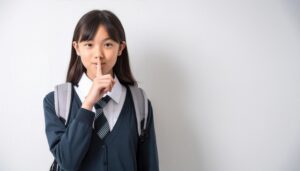 制服姿で静かにするジェスチャーをする学生