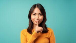 静かにというジェスチャーをする人物