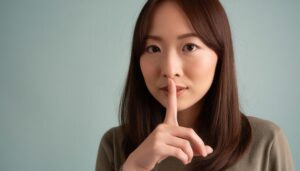 静かにと指で示す女性