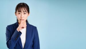 静かにと示すスーツの女性