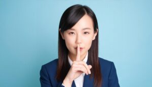 指を口に当て静かにと示すビジネスウーマン