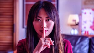 落ち着いた表情で指を口に当てる女性