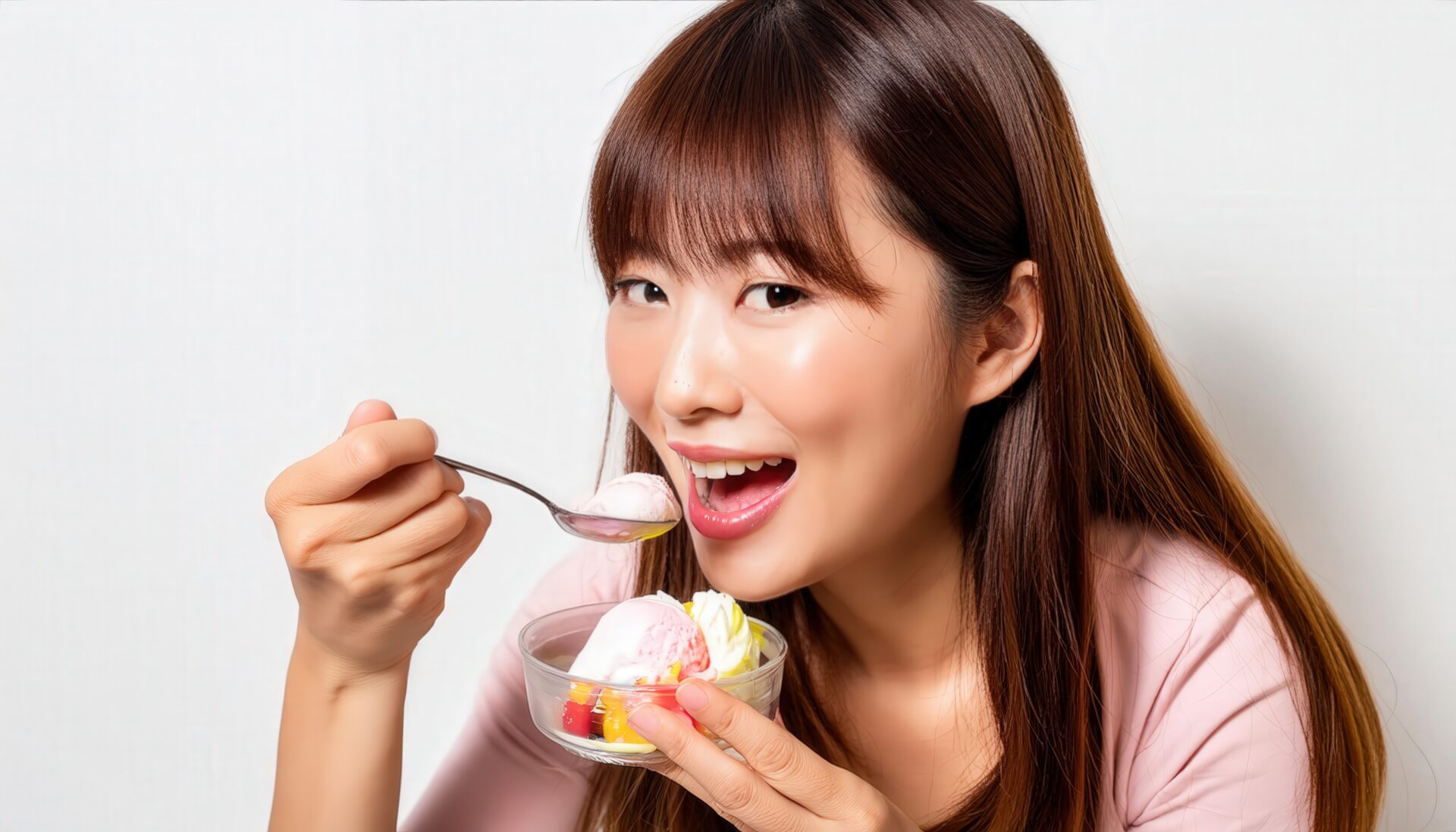 アイスクリームを食べる女性（ピンク服）