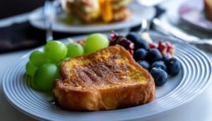 白いプレートに盛られたフレンチトーストとブルーベリーとぶどう