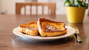 室内のダイニングテーブルに置かれた粉砂糖をまぶしたフレンチトースト