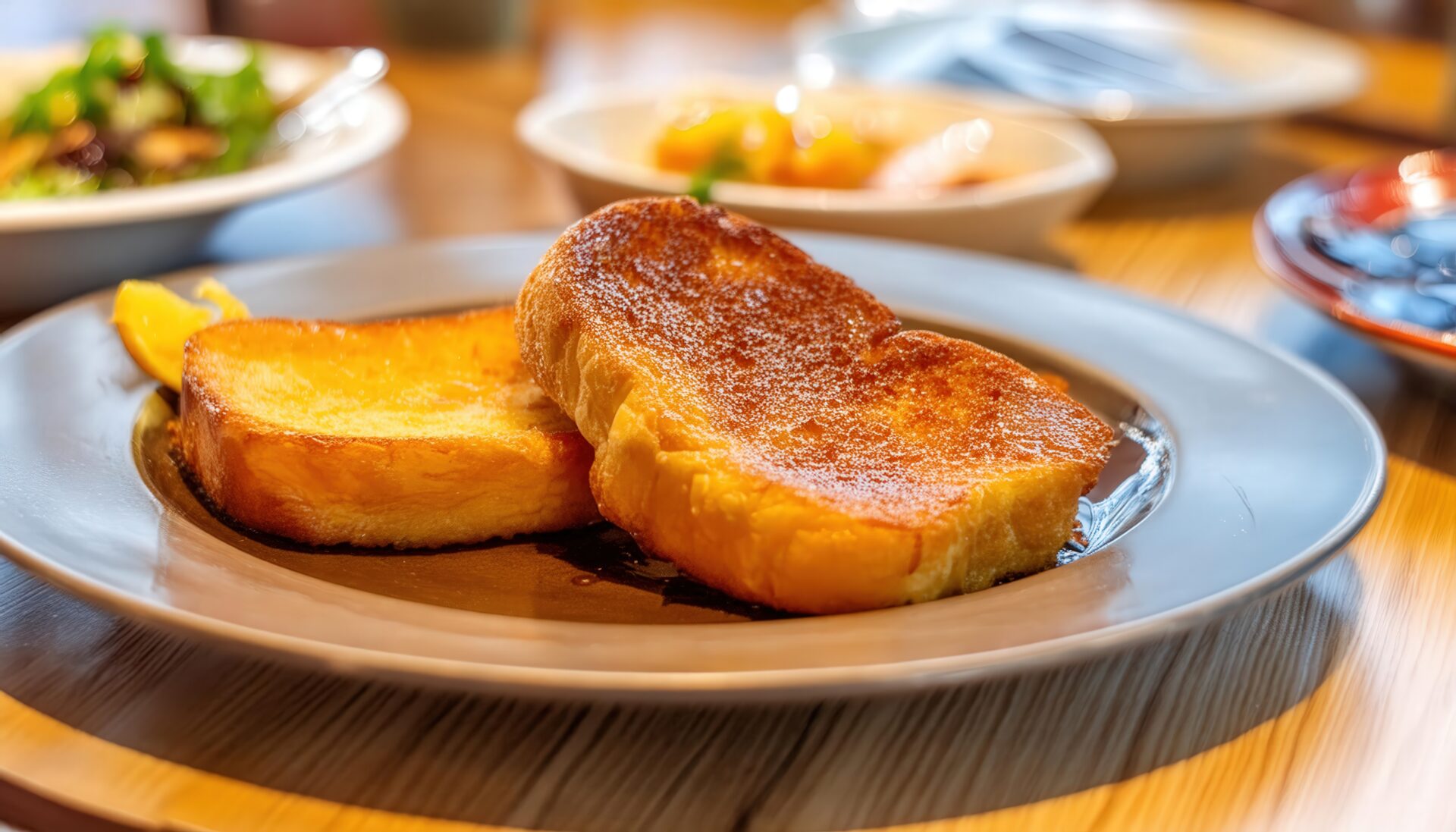 レストランのテーブルに並ぶフレンチトーストと複数の料理