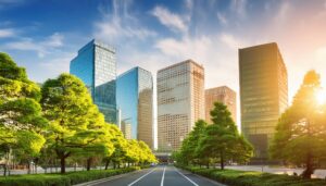 夕日に輝くオフィスビルと緑の並木道