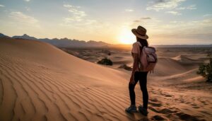 砂漠で夕焼けを見る旅行者