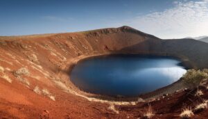 赤茶色の火山壁と鮮やかな青い湖水