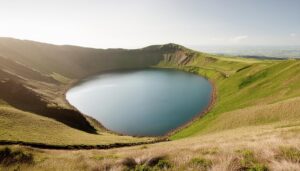 日の光に照らされた牧草地と穏やかな湖面