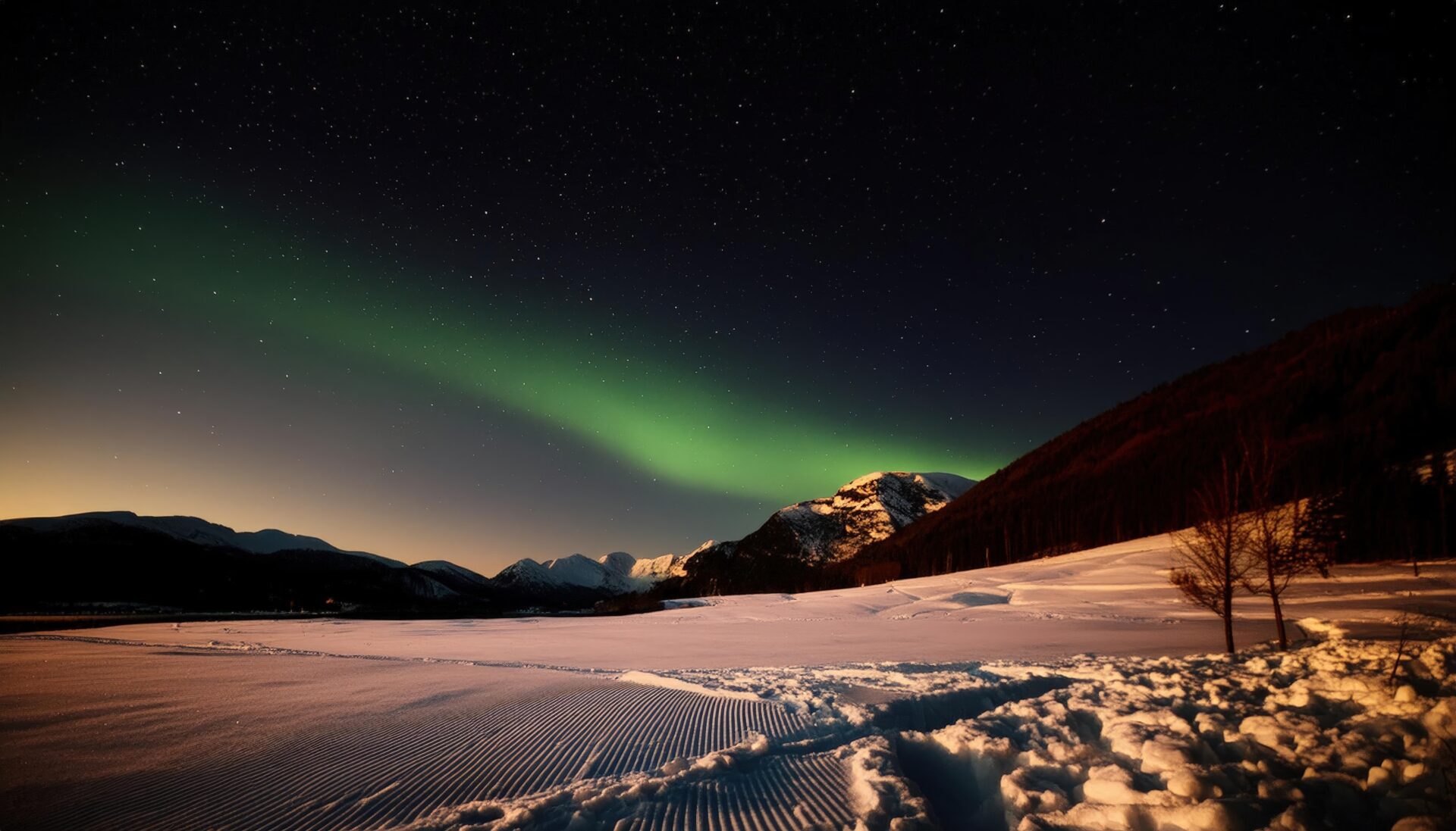 オーロラと雪山が織りなす夜空