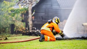 地面から放水する消防士